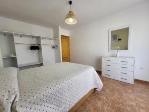 a bedroom with a bed and a dresser in it at Apartamento in Carboneras +9 photos