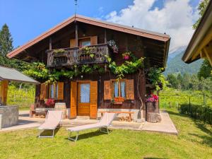 een huis met twee stoelen ervoor bij Chalet Relax Tra Le Vigne in Forni di Sotto