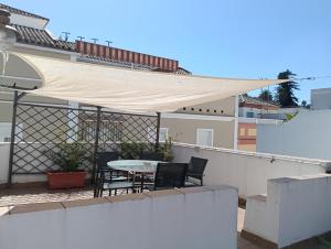 Un patio con una mesa y sillas en un balcón. en Casa Algarabía, en Sanlúcar de Barrameda
