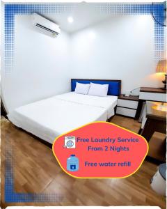 a bedroom with a white bed and a desk at Cat Ba Charm Island Hotel in Cat Ba