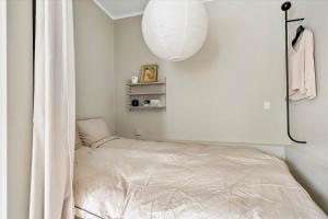 a small bedroom with a bed and a lamp at Charming studio apartment in the heart of Nørrebro, Copenhagen in Copenhagen