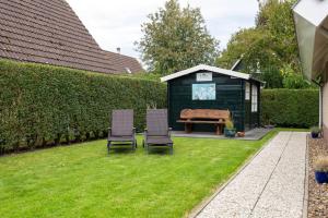 a garden with two chairs and a shed at Ferienhaus Weitblick in Sint Maarten
