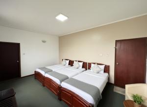 twee bedden in een kleine kamer met bij Kings Villa Nuwara Eliya in Nuwara Eliya