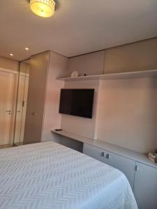 a bedroom with a bed and a flat screen tv at NOVO e DECORADO no Centro de Canela! in Canela