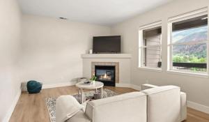 a living room with a couch and a fireplace at Riverfront Charm 3 Bed Condo with Mountain Views in Glenwood Springs