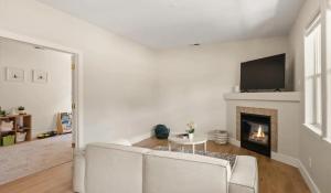 a living room with two white chairs and a fireplace at Riverfront Charm 3 Bed Condo with Mountain Views in Glenwood Springs