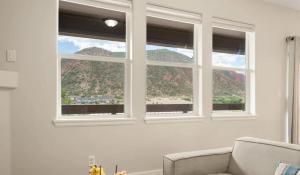 a living room with two windows and a couch at Riverfront Charm 3 Bed Condo with Mountain Views in Glenwood Springs +8 photos