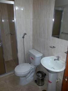 a bathroom with a toilet and a sink at Hotel Carrizal Suites in Barinas