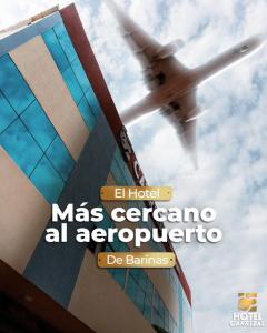 a plane is flying over a building with street signs at Hotel Carrizal Suites in Barinas