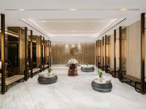 a lobby of a luxury hotel with tables and flowers at Radisson Lampung Kedaton in Bandar Lampung