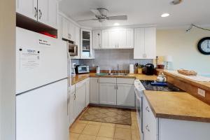 a kitchen with white cabinets and a white refrigerator at Sand Dollar II 303 in Ocean City