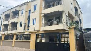 a large white building with a black garage at Shabi's Court in Lagos
