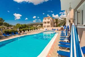 a pool with lounge chairs and umbrellas at a resort at Garden Palace Hotel in Laganas