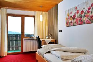 a hotel room with a bed and a balcony at Frühstückspension Bilgeri in Sulzberg