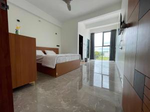 a bedroom with a bed and a sliding glass door at Hotel O DSP Lodge And Restaurant in Jadhavwadi