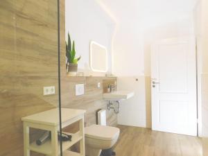 a bathroom with a toilet and a sink at FeWo "Hafenquartier" in Barth +12 photos