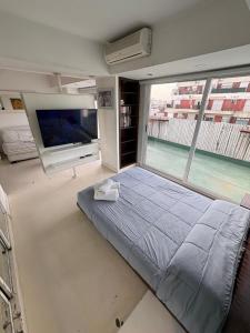 En eller flere senge i et værelse på Apart Recoleta con jacuzzi y balcón con parrilla propio