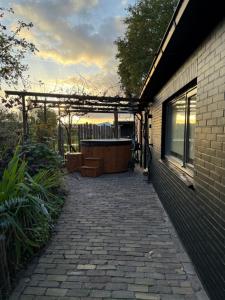a patio with a hot tub and a building at B&B Het Kleine Huisje met Hottub in Emmen