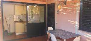 una pequeña cocina con mesa y puerta negra en Caserta Holiday Rent, en Ustica 11 fotos más