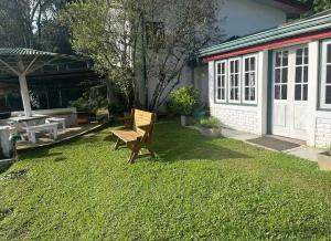 埃拉Ella Escapade Hostel的院子里有一张长凳、一张桌子和一栋建筑