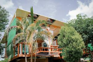 a house with a palm tree in front of it at Nam garden lodge in Tân Phú