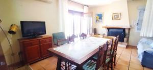 a living room with a dining table and a tv at La Casa Maria in Pego