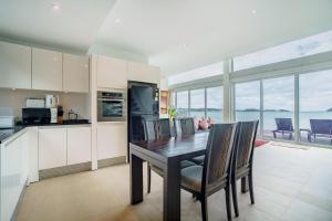 a kitchen and dining room with a table and chairs at Raya Villa, 2 Bed Beachfront Villa Private Pool in Ban Saiyuan (1)