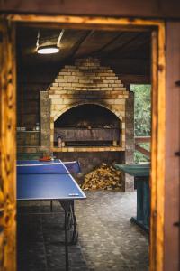 a ping pong table in front of a brick oven at Spadok in Krasnyy