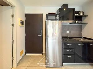 a kitchen with a stainless steel refrigerator and a door at Condo for rent CHALONG RAWAI PHUKET in Ban Klang