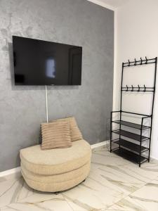 a living room with a chair and a flat screen tv at Apartman na dan Pecinci in Pećinci