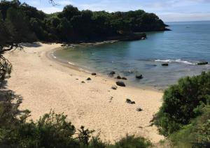 a sandy beach with rocks in the water at Maison de village in Île dʼAix