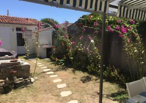 a garden with pink flowers on a fence at Maison de village in Île dʼAix +2 photos
