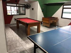 Una mesa de ping pong en una habitación con una pelota de ping pong en Apto até 6 pessoas -PG Aviação - 150mts e 1 vaga, en Praia Grande 22 fotos más