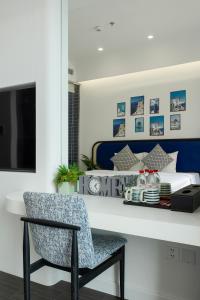 a bedroom with a bed and a chair and a desk at Atermis Regency Hillside Phu Quoc - Sea & Fireworks view- Gym & Pool Access in Phu Quoc