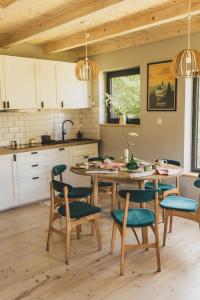 a kitchen with a table and chairs in a kitchen at Slow Huts in Miedzygorze