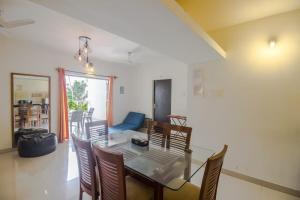 a dining room with a glass table and chairs at Hidden Gem 3bhk with unlimited internet in Candolim