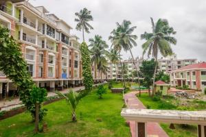 a view of an apartment complex with palm trees at Hidden Gem 3bhk with unlimited internet in Candolim +12 photos