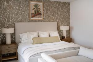 a bedroom with a bed and two lamps and a chair at Stylish West Coast 3BR Retreat with Pool Near Beach in Saint James