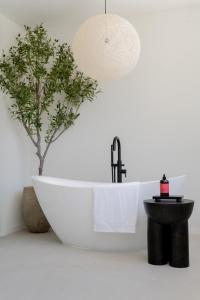 a bathroom with a bath tub and a tree at Stylish West Coast 3BR Retreat with Pool Near Beach in Saint James