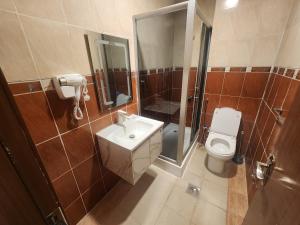 a bathroom with a toilet and a sink and a shower at شقق مفروشة الهتون تاور شارع الحج in Miná +35 photos