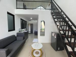 ein Wohnzimmer mit einer Couch und einer Treppe in der Unterkunft Sovilla Prime Yogyakarta in Ngaglik