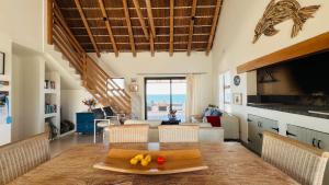 a kitchen and living room with a table with fruit on it at Kleinbos Beach Villa in Boggomsbaai