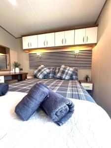 Un dormitorio con una cama con sábanas y almohadas azules. en Seashell Retreat, en Cayton