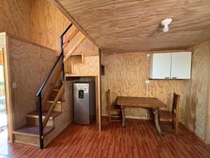 Una pequeña casa con una escalera, una mesa y un refrigerador. en Tiny House in Valdivia, en Valdivia
