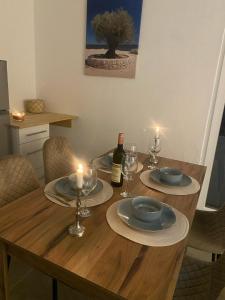 a wooden table with plates and glasses and a bottle of wine at Welcome to our vacation home in Sutomore in Sutomore