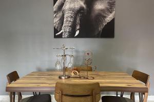 a dining room table with an elephant painting on the wall at Tamaniroom- a private 1bed in Tamale