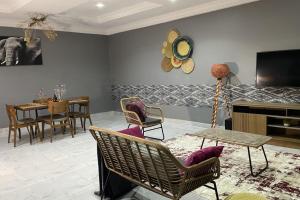 a living room with chairs and a table and a tv at Tamaniroom- a private 1bed in Tamale
