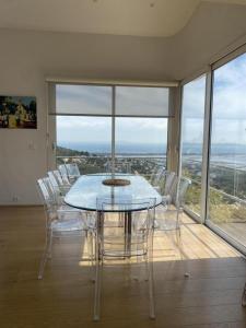 Un comedor con una mesa de cristal y sillas blancas. en "maison calypso", en Hyères