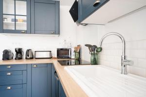 una cucina con mobili blu e un lavandino di La Longère des Surfeurs - Plage Bud Bud - Calme a Longeville-sur-Mer