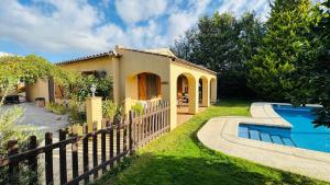 een huis met een hek naast een zwembad bij Apartment with private pool and garden in San Martín Sarroca